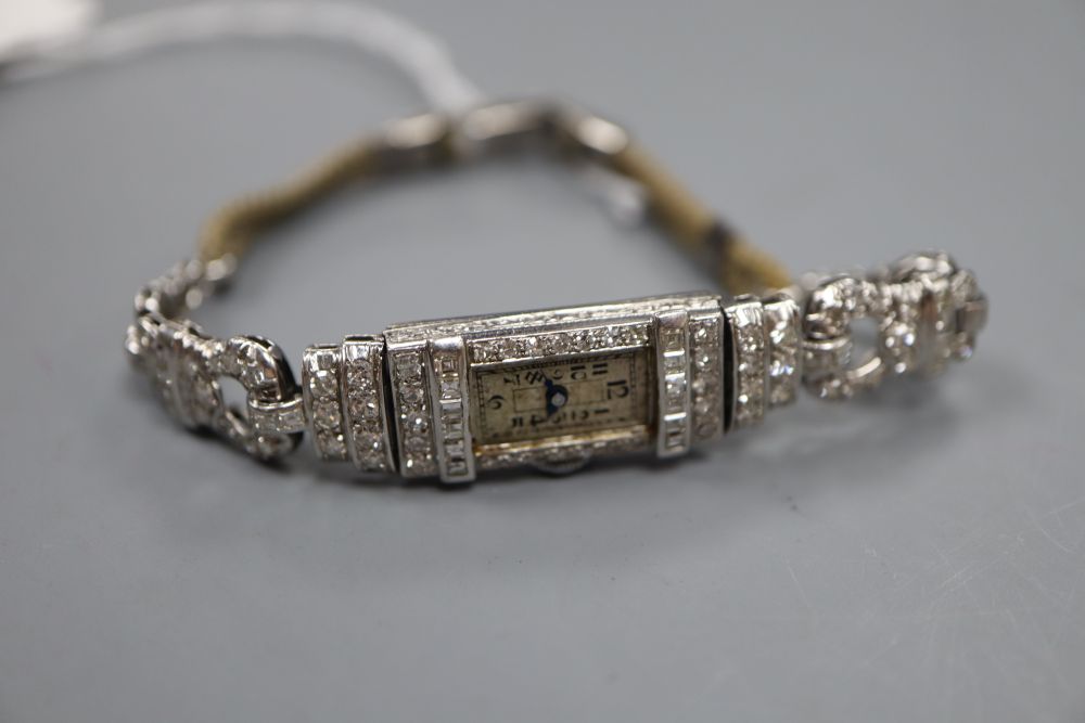 A ladys Art Deco white metal (stamped platinum) and diamond set cocktail watch, with fabric strap, 16.7cm, gross 16.1 grams.